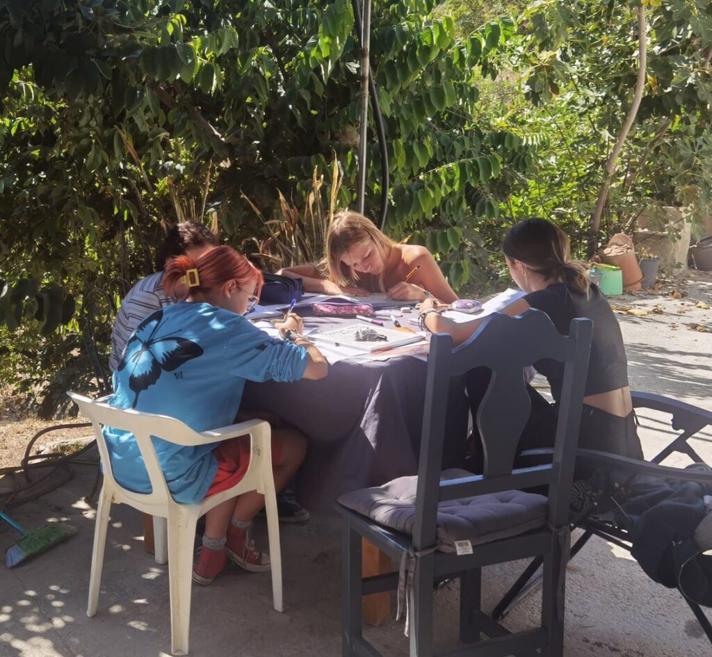 Group of teenagers doing homework at outside table