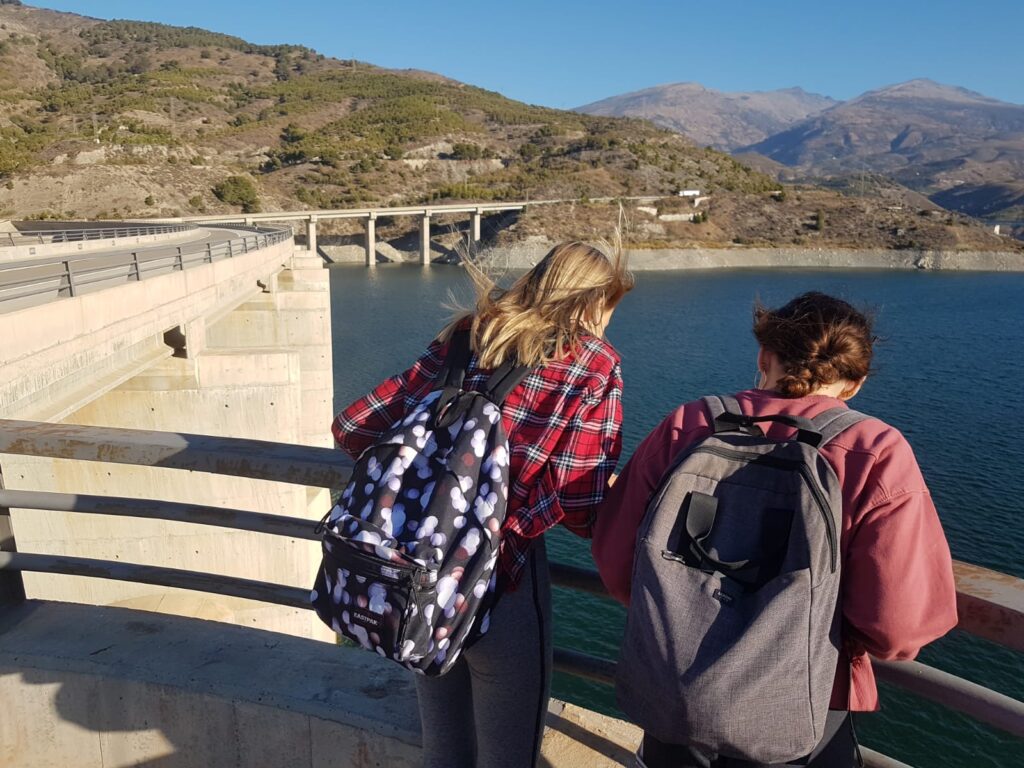 Two students looking over bridge railing